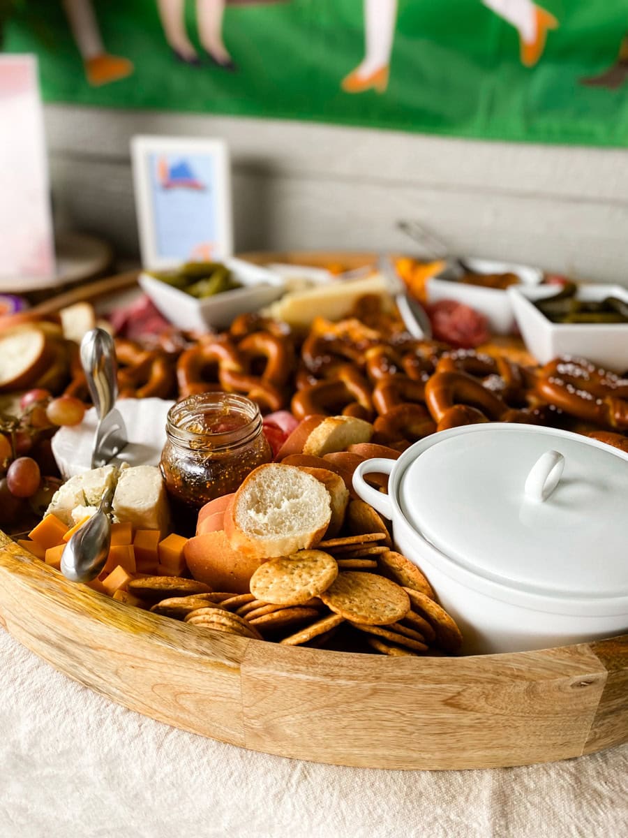 Close-up of adult Oktoberfest party charcuterie board with brie, cheddar, fig jam, and salami rosettes