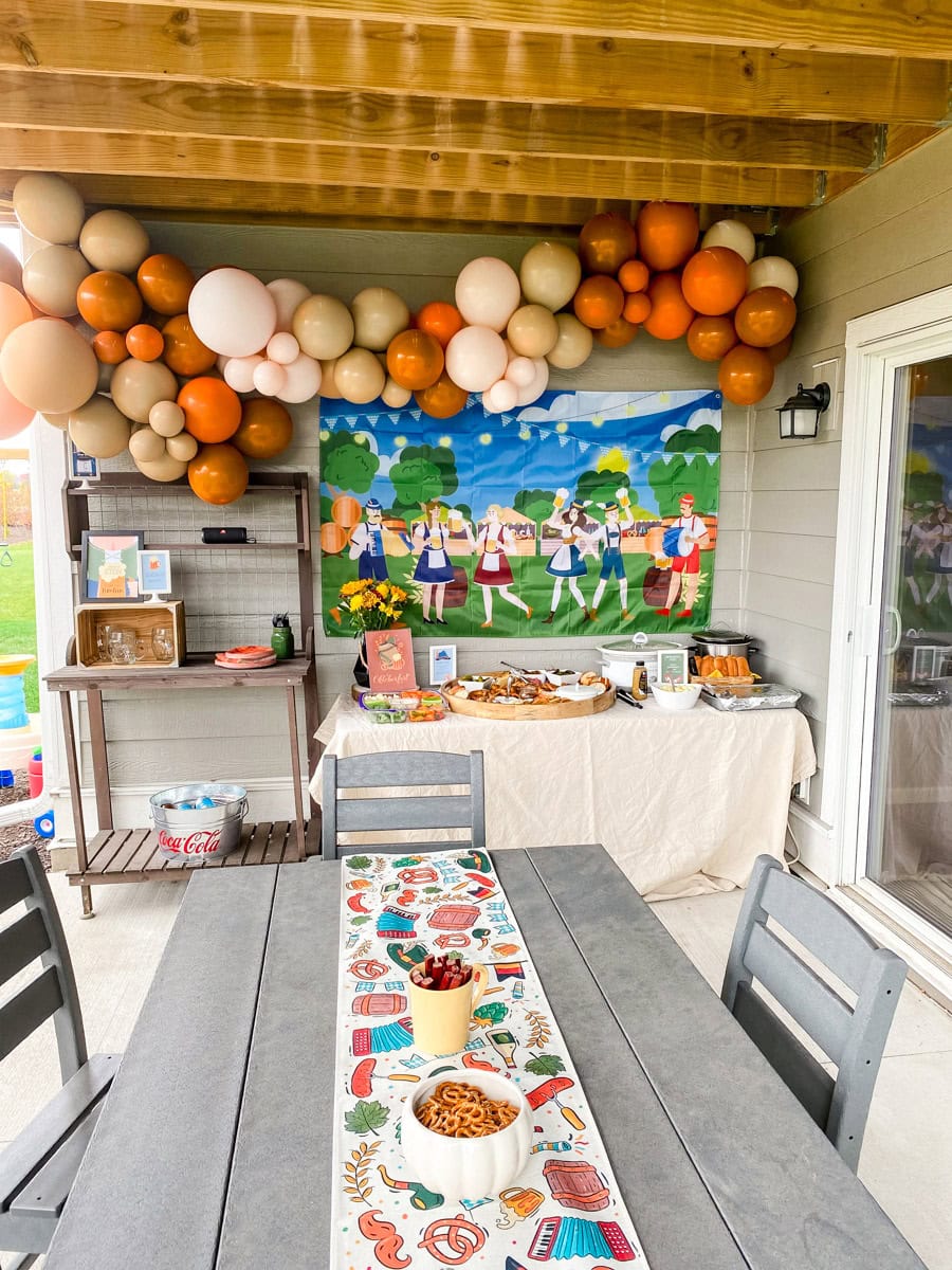 Adult Oktoberfest party dining table with colorful Oktoberfest icon table runner and pretzel bowls