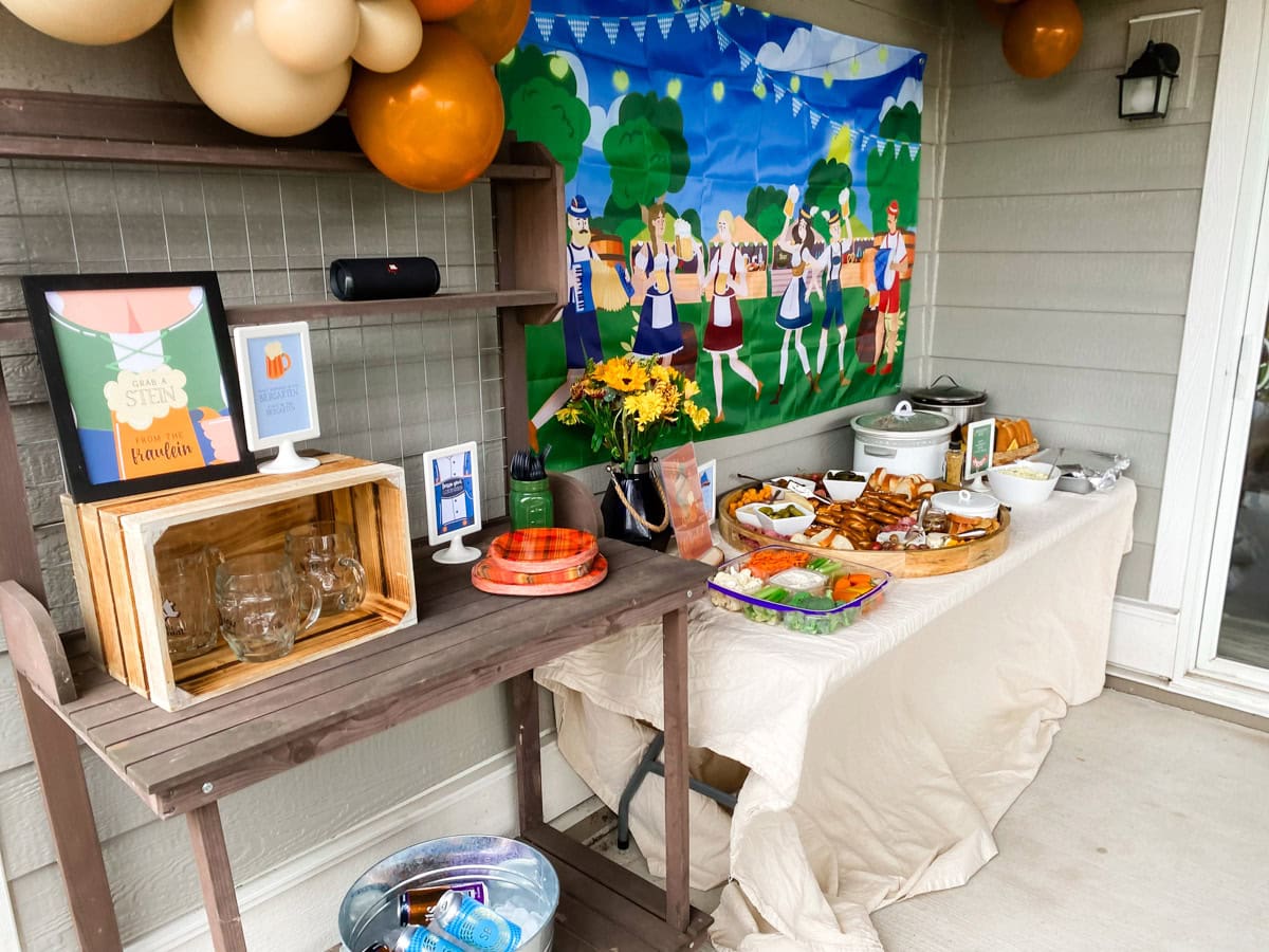 Adult Oktoberfest party fraulein theme drink station with glass beer stein mugs, Grab a Stein from the Fraulein printable sign, and drink bucket