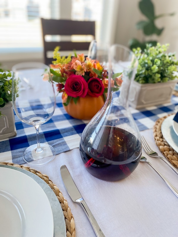 wine carafe on table with pumpkin floral centerpiece