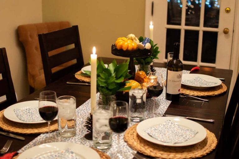 Fall tablescape with glowing ambient light from candles create a cozy atmosphere for a dinner in.