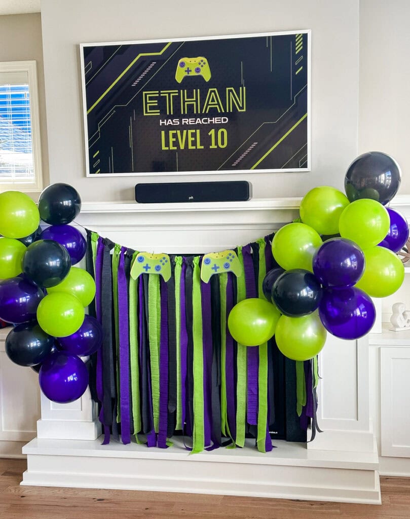 Close-up of lime green, black, and purple balloon cluster at gamer birthday party fireplace mantel backdrop