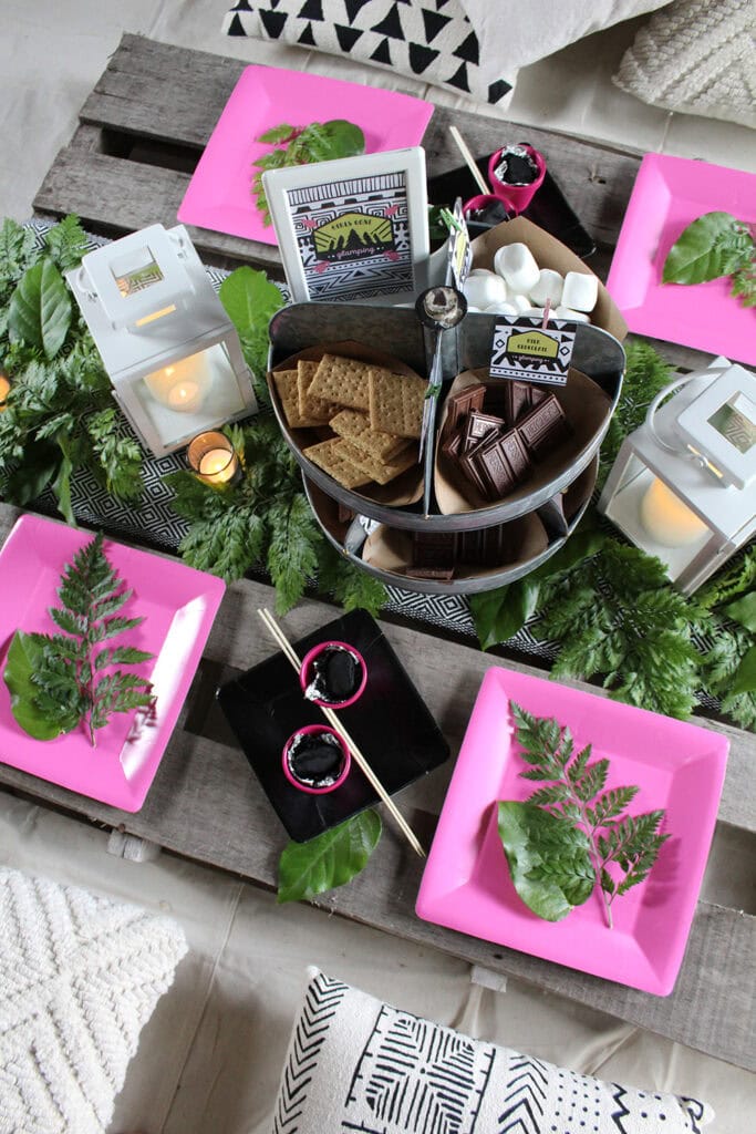 overhead view of glamping party tablescape with greenery and lanterns