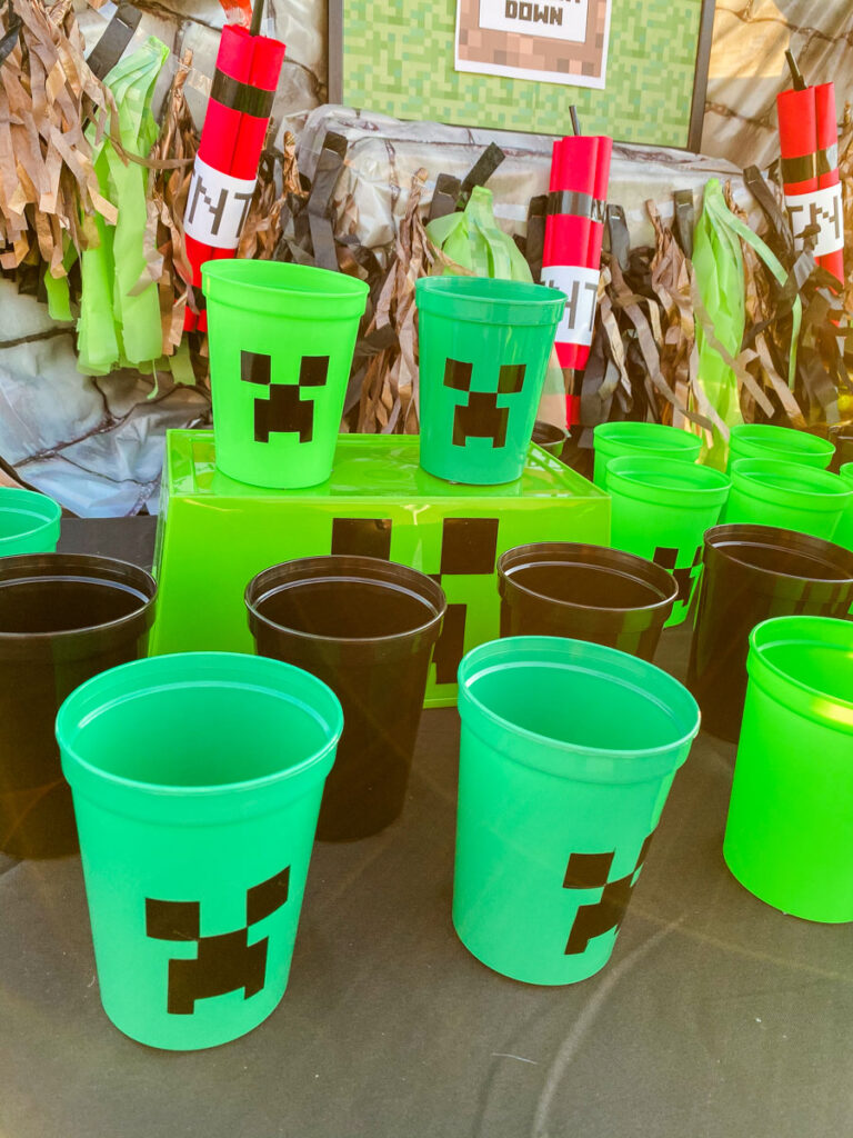 Minecraft Creeper Cup game cups with vinyl Creeper faces set against a TNT dynamite garland backdrop