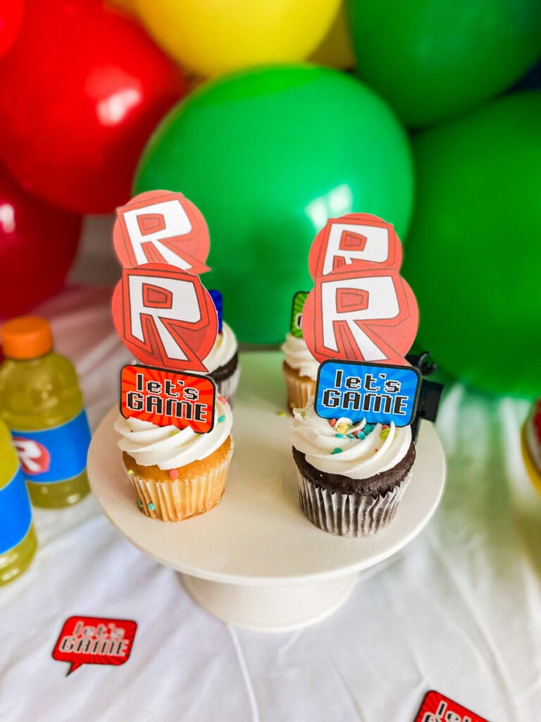 Roblox birthday party cupcakes on white cake stand with Roblox R logo toppers and Let's Game tags