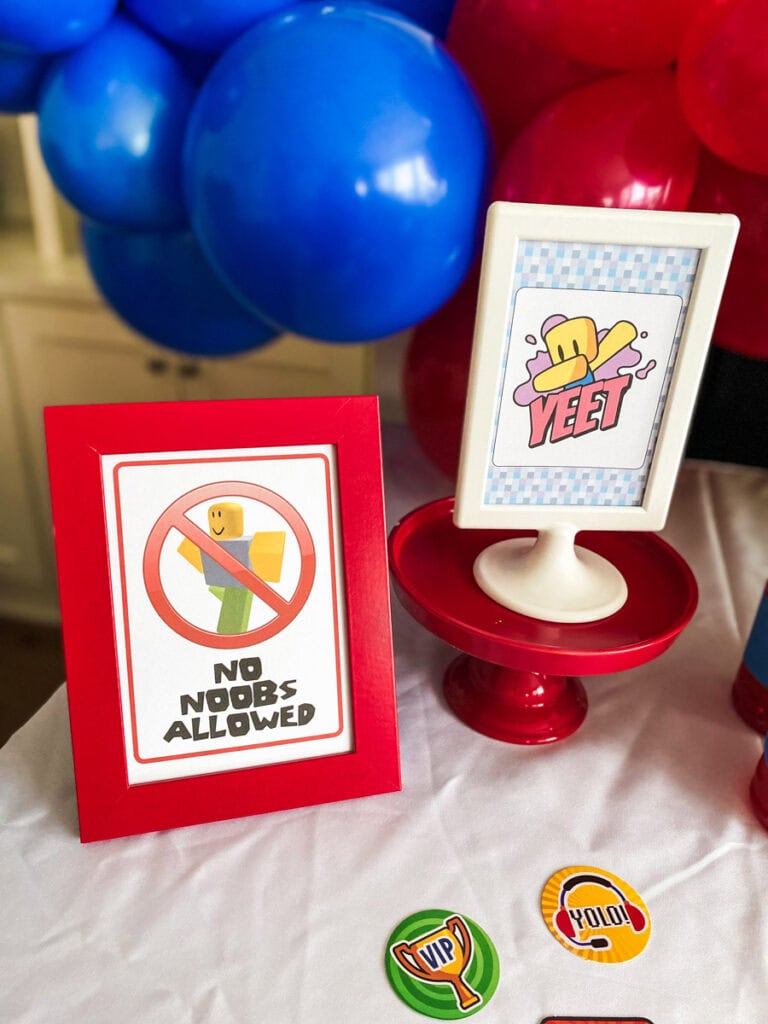 No Noobs Allowed and YEET Roblox birthday party printable signs in red and white frames with Roblox table confetti