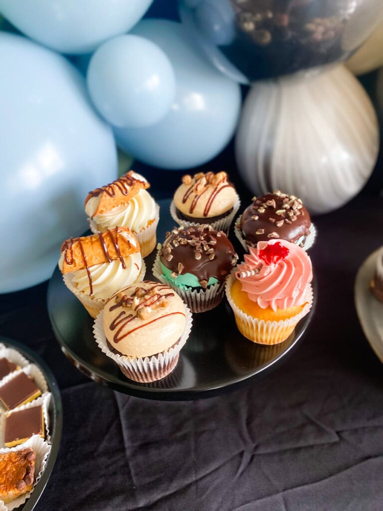 Specialty cupcakes on black cake stand at muted Star Wars birthday party dessert table