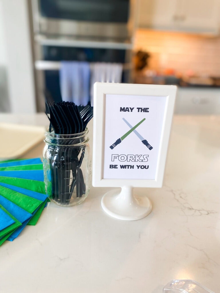 May the Forks Be With You Star Wars printable sign with crossed lightsabers next to silverware jar