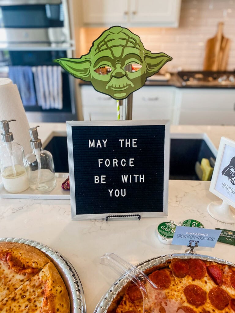 Yoda mask decoration and May the Force Be With You letter board at Star Wars party food buffet